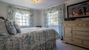A bedroom with a large bed, a dresser, and a painting on the wall. - Located in the Luxurious Pine Manor Estates! (Carbondale)