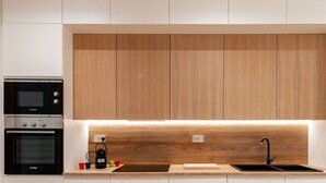 Une cuisine moderne avec des meubles en bois, un four encastré et un évier.