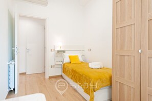 Un dormitorio con una cama, un armario de madera y un radiador.