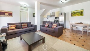 A modern living room with two sofas, a coffee table, and a dining area with a table and chairs.