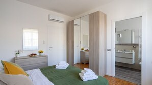 Un dormitorio moderno con cama, mesita de noche y espejo.