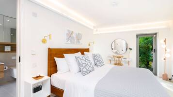 A modern bedroom with a wooden bed, bedside tables, a vanity with a mirror, and a view of greenery outside.