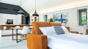 Un dormitorio moderno con una cama grande, un comedor y una cocina.