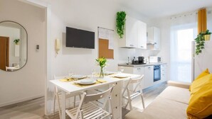 Un apartamento moderno y bien iluminado con comedor, kitchenette y sala de estar.