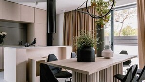 A modern kitchen with a central island, black chairs, and a large window with curtains. - Luxury Villa Hera in Vodice (Srima)