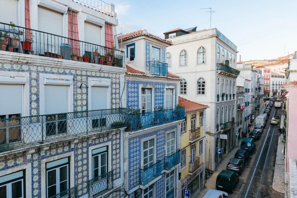 A row of colorful buildings with balconies and a street in front.