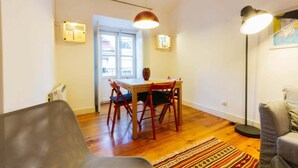 Un espacio habitable compacto con comedor, sofá y lámpara de pie.