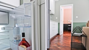 Un refrigerador abierto con una botella de agua y una botella de vino tinto.