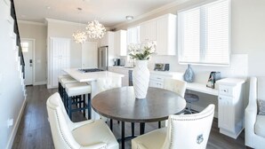 A modern kitchen with white cabinetry, a central island, and pendant lighting. - 4046 · Modern condo in Hillcrest/Mission Hills (San Diego)