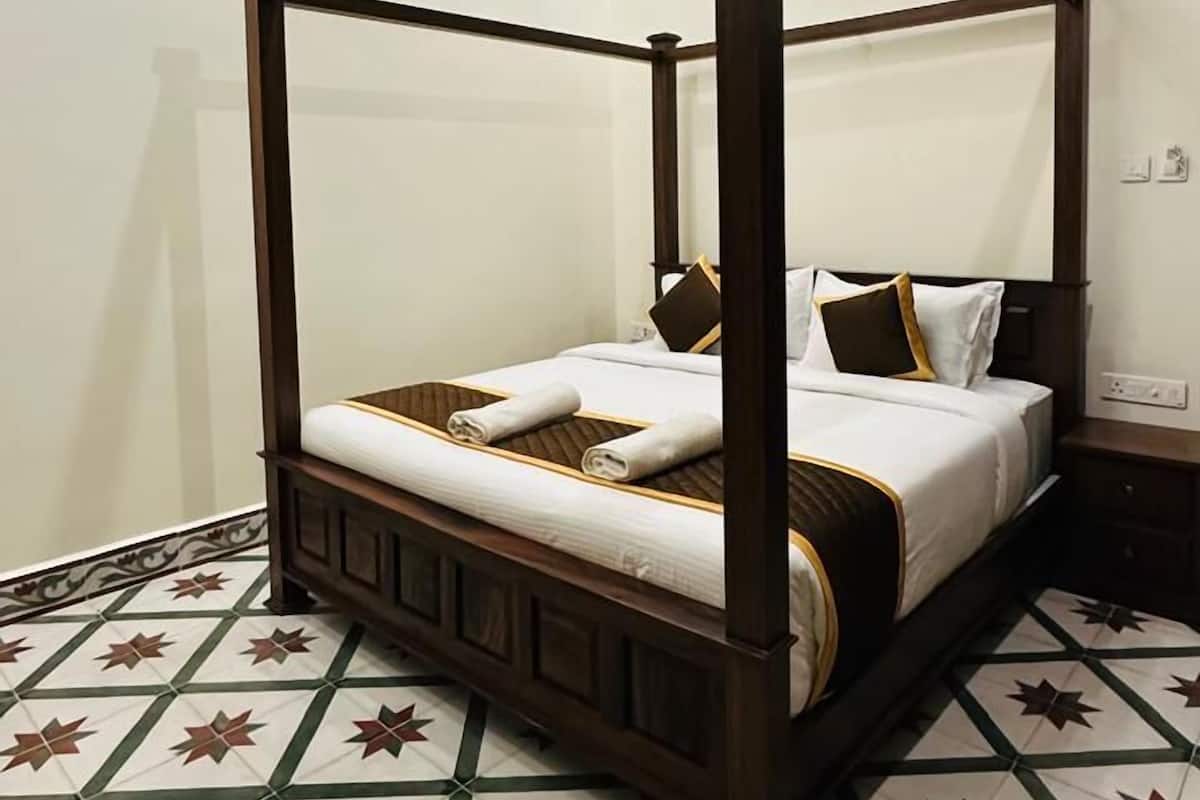 Ein Himmelbett mit Baldachin, ein Deckenventilator und ein Musterboden.