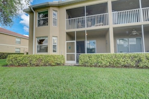 A two-story building with a balcony, large windows, and a well-maintained lawn. - Cypress Woods for Seasonal or Summer Stays (Naples)