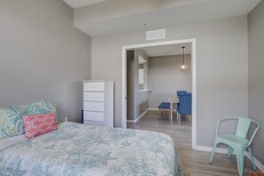 A bedroom with a bed, a dresser, a chair, and a dining area with a table and chairs. - Cypress Woods for Seasonal or Summer Stays (Naples)