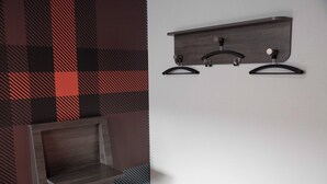 A modern bathroom with a dark wood vanity, a towel rack, and a shower area.