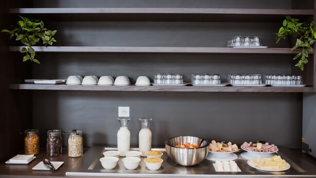 A buffet setup with various food items and condiments on shelves and counters.