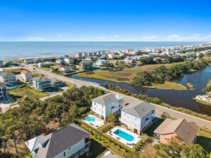 Un quartier résidentiel situé sur la côte, avec des maisons, une piscine et une rivière.