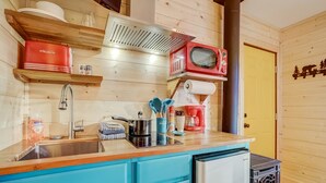 A compact kitchen with wooden walls, a sink, a stove, and a microwave. - Tahoe Mountain Inn #9 (South Lake Tahoe)