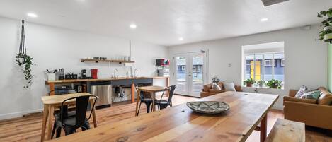 Una cocina moderna con encimeras de madera, un comedor con una mesa grande de madera y una sala de estar acogedora con un sofá y un televisor.