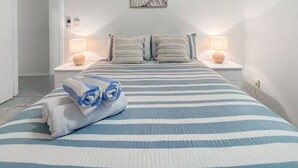 Ein Hotelzimmer mit Bett, zwei Nachttischen, einem Wandbild und einer Tür.