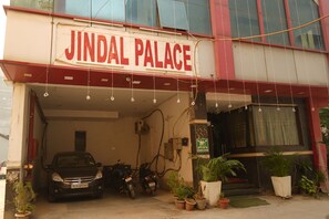 A building with a sign reading "Jindal Palace." There are several potted plants in front of the entrance. - Hotel J. Palace (New Delhi)