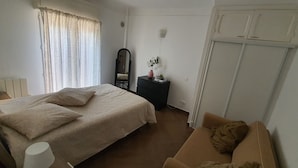 Une chambre à coucher comprenant un lit, une commode, un miroir, une table de chevet, une lampe et une armoire.
