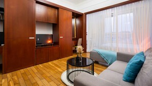 A modern living room with a sofa, a coffee table, and wooden cabinets. - The Manor  Apartment Nguyen Huu Canh (Ho Chi Minh City)
