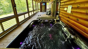 A wooden cabin with a hot tub, wooden deck, and large windows overlooking a forest. - Hidden Creek Cabin Sleeps 8 • Hot Tub • Game Room • 8 Min to Downtown (Blue Ridge)