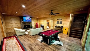 A cozy room with a pool table, a fireplace, and a television. - Hidden Creek Cabin Sleeps 8 • Hot Tub • Game Room • 8 Min to Downtown (Blue Ridge)