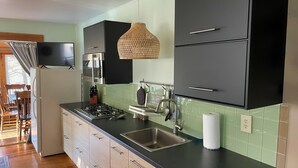 Una cocina moderna con gabinetes negros, un fregadero de acero inoxidable y una estufa a gas.