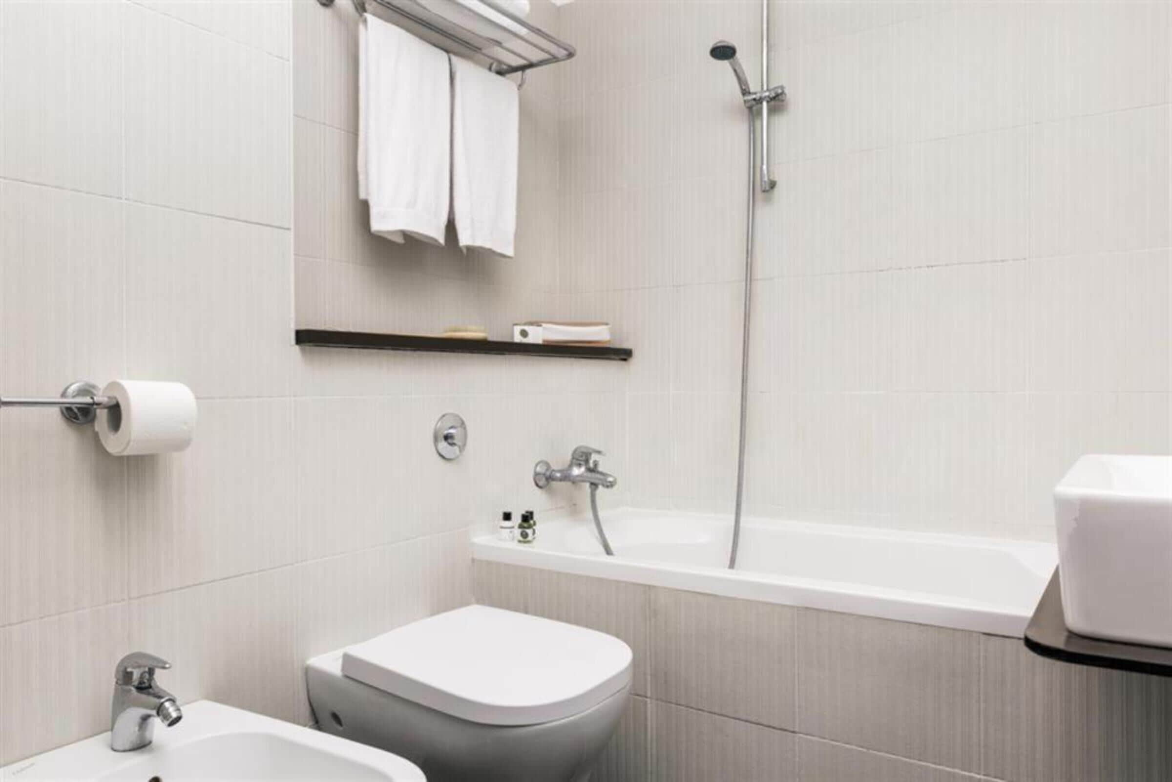 Ein modernes Badezimmer mit Toilette, Waschbecken und Badewanne.