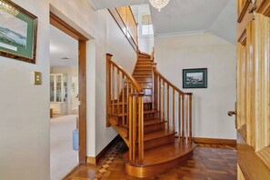 Una escalera de madera con barandilla que lleva a un piso superior.