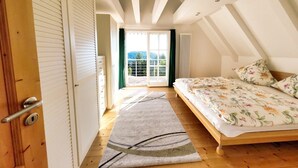 A bedroom with a bed, a window, and a door. - Holiday home mountain idyll (Sasbachwalden)