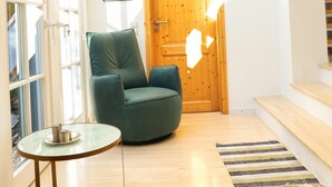 A modern loft bedroom with a skylight, wooden door, and a green armchair. - Holiday home mountain idyll (Sasbachwalden)