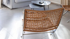 A bright room with a sofa, a wicker chair, and a table. - Villa Claire à Andernos - sea view with heated poo (Andernos-les-Bains)