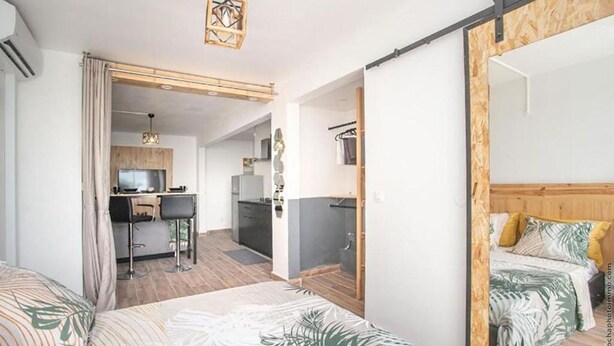 Une chambre d’hôtel avec un lit, un bureau et une kitchenette.