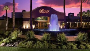 A hotel with a fountain in front, palm trees, and a sunset sky. - Luxury Private Townhome @ TPC | GOLF Garage & Pool (Scottsdale)