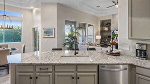 A modern kitchen with granite countertops, stainless steel appliances, and a central island. - Luxury Private Townhome @ TPC | GOLF Garage & Pool (Scottsdale)