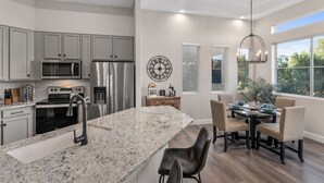A modern kitchen with granite countertops, stainless steel appliances, and a large island. - Luxury Private Townhome @ TPC | GOLF Garage & Pool (Scottsdale)