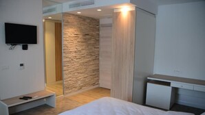 A modern bedroom with a bed, a desk, and a TV mounted on the wall. - Nar Hotel (Trebinje)
