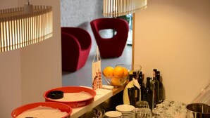 A buffet setup with a variety of food items, a selection of beverages, and a seating area with red chairs. - Nar Hotel (Trebinje)