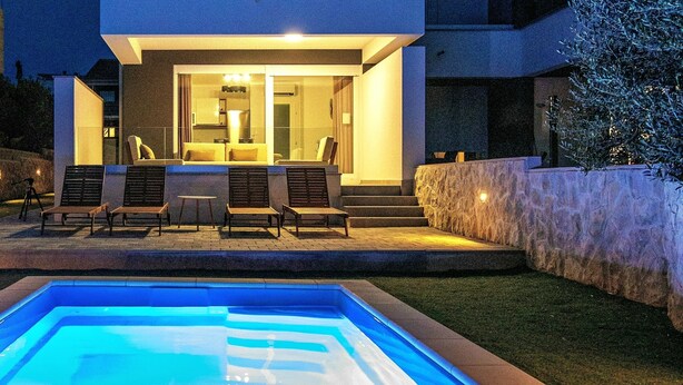 Un immeuble moderne à plusieurs étages, avec une piscine en premier plan.