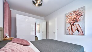 Une chambre à coucher avec un lit, une armoire et un tableau accroché au mur.