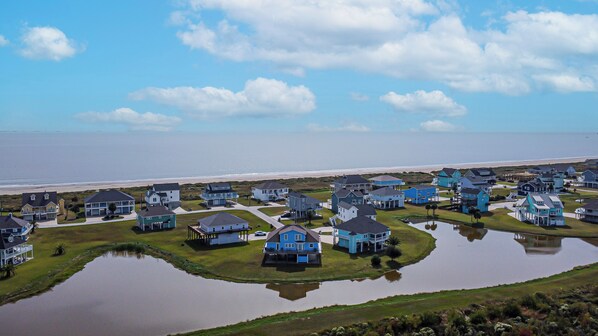 A coastal residential area with houses, a beach, and a body of water.