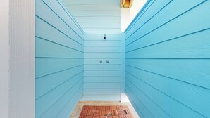 A narrow hallway with light blue wooden walls and a small wooden door at the end. - Biscayne Seaglass: 4 BR, 3 BA House in Port Bolivar, Sleeps 12 (Bolivar Peninsula)