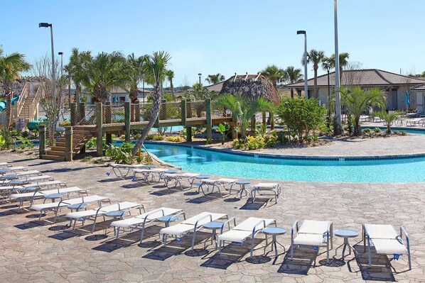 A pool area with lounge chairs and a small pool.