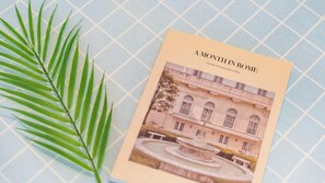 A book titled "A Month in Rome" with a photograph of a classical building and a fountain.