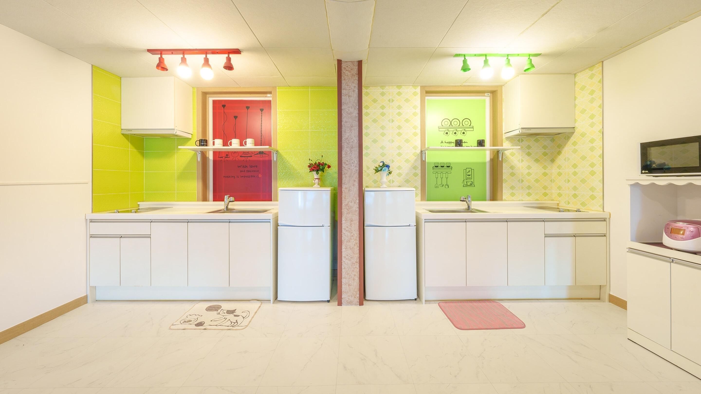 Une cuisine moderne dotée de deux éviers, de meubles blancs et d’un revêtement mural coloré.