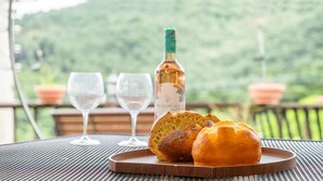 A table with a bottle of wine, two glasses, and two loaves of bread on a tray.