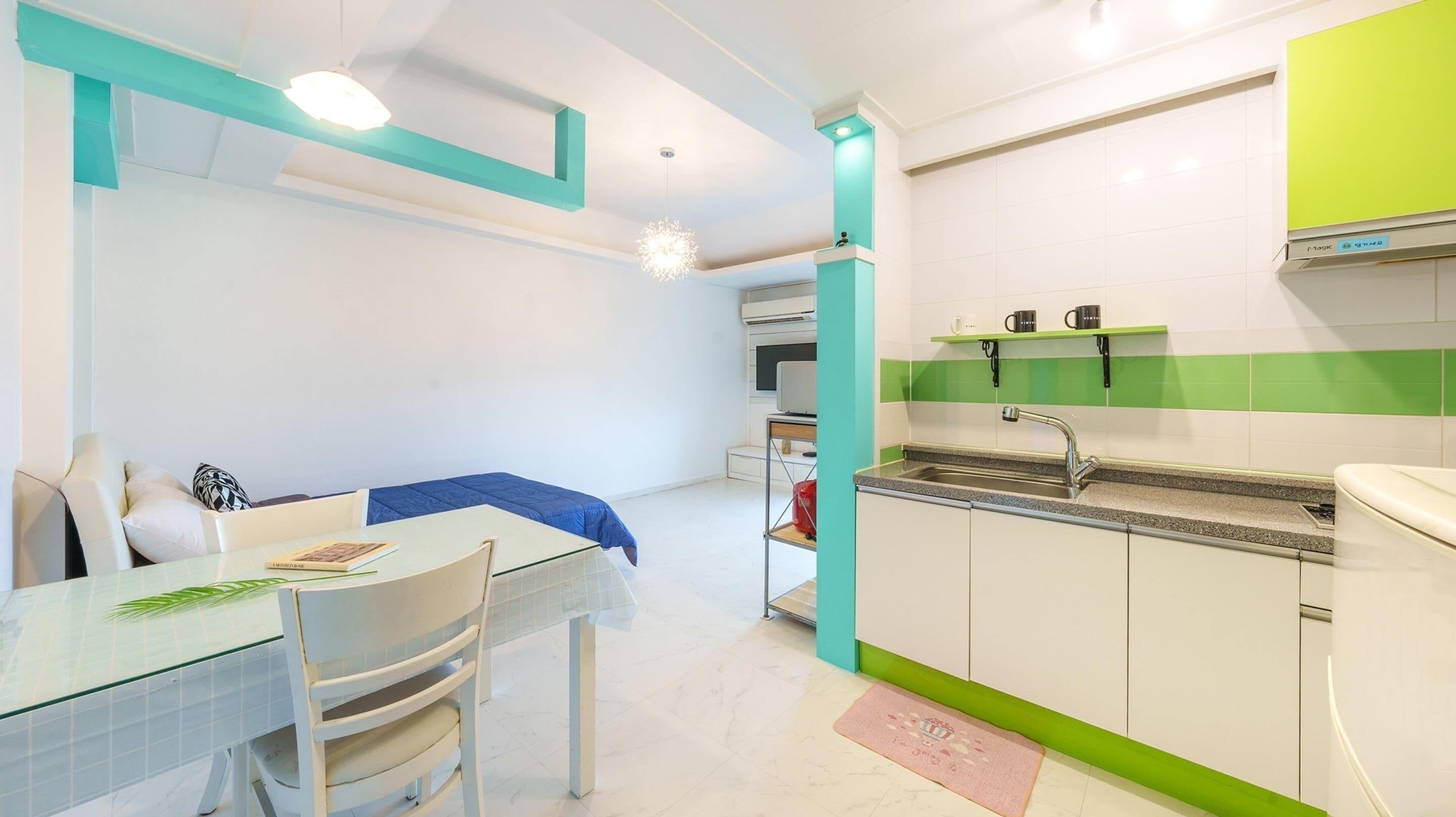 Una cocina moderna con un lavamanos, encimera y una zona de comedor con mesa y sillas.