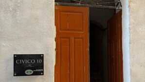 A door with a sign reading "CIVICO 10" and a fan above it. - Civic 10 II Spacious studio apartment with terrace above at Sassari Center (Sassari)