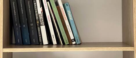 Una estantería con libros y una planta en maceta.